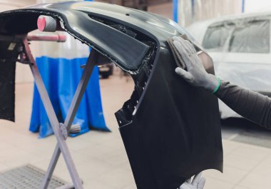 Otomatik tamirci güç tampon makinesi ile cilasını uygulayarak arabayı boya işi için hazırlıyor