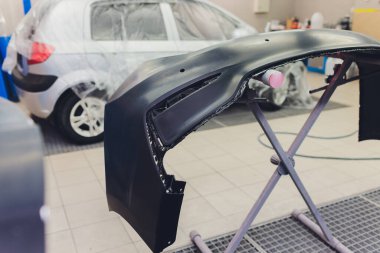 Otomatik tamirci güç tampon makinesi ile cilasını uygulayarak arabayı boya işi için hazırlıyor