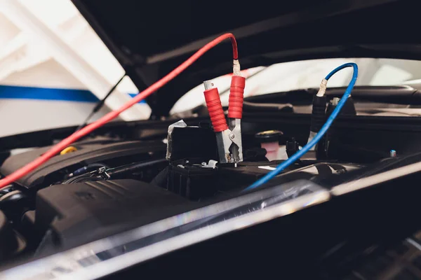 Selective focus charging car with electricity trough cables. — Stock Photo, Image