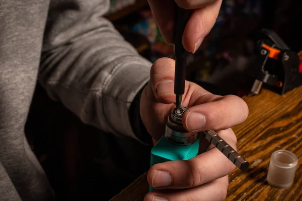 Vape. Ein Mann in einem Vaporetto-Laden repariert E-Zigaretten. — Stockfoto