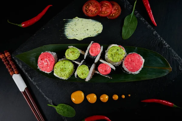 Geleneksel Japon yemekleri - suşi, rulo ekmek ve siyah arka planda sos. Üst görünüm. — Stok fotoğraf