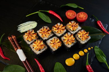 Geleneksel Japon yemekleri - suşi, rulo ekmek ve siyah arka planda sos. Üst görünüm.