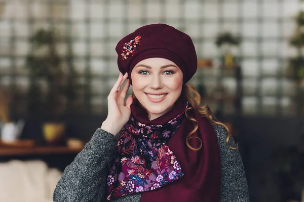 Verbaasd gelukkig mooie vrouw op zoek zijwaarts in opwinding. Kerst meisje het dragen van warme gebreide muts en de wanten, geïsoleerd op een grijze achtergrond. — Stockfoto