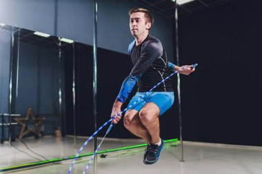 Kaslı adam ip atlama. Siyah arka plan üzerine ip atlama ile egzersiz kas genç adam portresi.