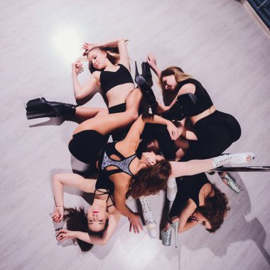 Genç striptizci, yüksek topuklu ayakkabıyla dans ediyor..