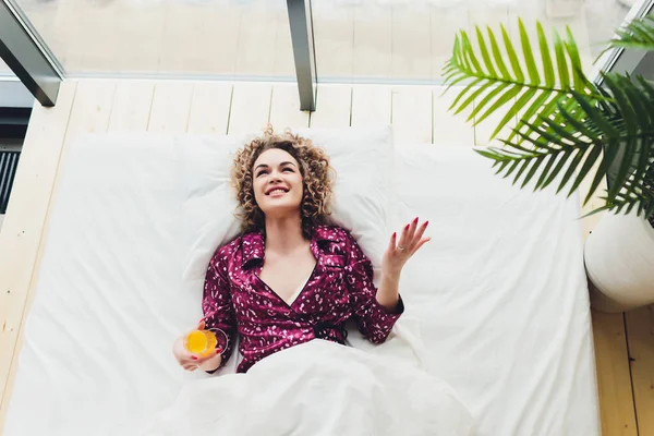 Mujer en la cama del hotel que cubre uno mismo con la hoja . —  Fotos de Stock