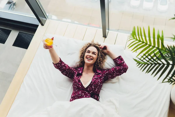 Mujer en la cama del hotel que cubre uno mismo con la hoja . —  Fotos de Stock