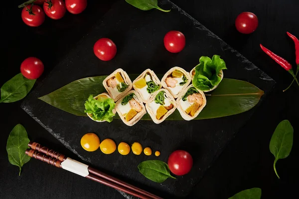 Comida japonesa tradicional - sushi, rolos e molho em um contexto preto. Vista superior . — Fotografia de Stock