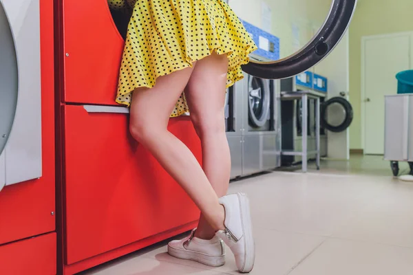 Женщина в ванной кладет голову в стиральную машину . — стоковое фото