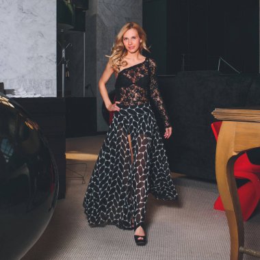 Siyah gece elbisesi giymiş güzel bir kadın. Restoran barında poz vermiş, kameraya bakıyor. .