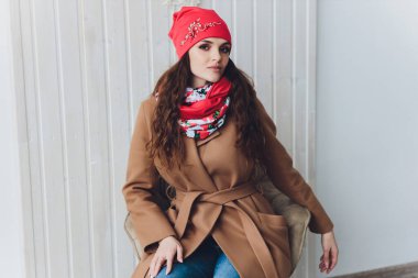 Yana doğru heyecan arayan sürpriz mutlu güzel kadın. Örme sıcak şapka ve gri arka plan üzerinde izole eldivenler giymiş Noel kız.