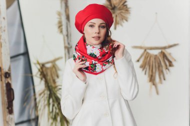 Yana doğru heyecan arayan sürpriz mutlu güzel kadın. Örme sıcak şapka ve gri arka plan üzerinde izole eldivenler giymiş Noel kız.