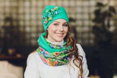 Yana doğru heyecan arayan sürpriz mutlu güzel kadın. Örme sıcak şapka ve gri arka plan üzerinde izole eldivenler giymiş Noel kız.