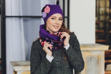 Yana doğru heyecan arayan sürpriz mutlu güzel kadın. Örme sıcak şapka ve gri arka plan üzerinde izole eldivenler giymiş Noel kız.