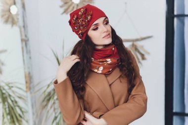 Yana doğru heyecan arayan sürpriz mutlu güzel kadın. Örme sıcak şapka ve gri arka plan üzerinde izole eldivenler giymiş Noel kız.