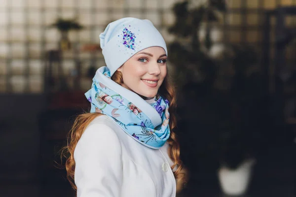 Verbaasd gelukkig mooie vrouw op zoek zijwaarts in opwinding. Kerst meisje het dragen van warme gebreide muts en de wanten, geïsoleerd op een grijze achtergrond. — Stockfoto