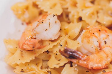 Kızarmış karidesli makarna, beşamel sosu, nane yaprağı, sarımsak, domates, beyaz tabakta kırmızı biber, İtalyan mutfağı..