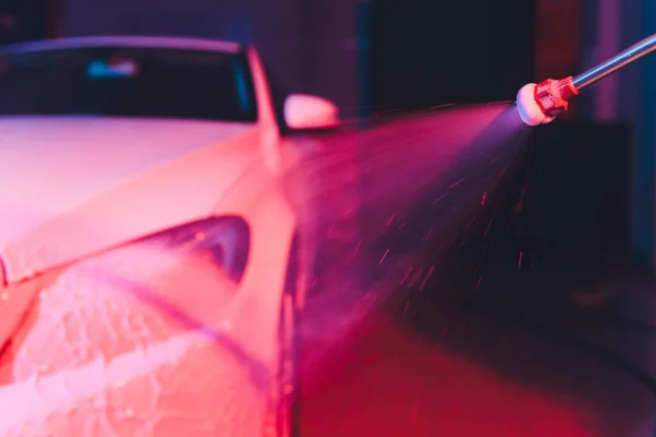 Cerrar coche de limpieza con agua de alta presión, lavadora de chorro de alta presión en proceso de lavado de coches. espuma de color rosa — Foto de Stock