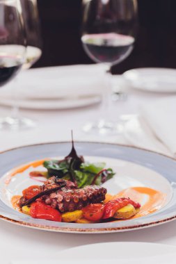 Sebze ve mürekkep balığı soslu ızgara ahtapot. Restoran, yaşam tarzı, seyahat yemekleri sebzeli ızgara ahtapot ve restoran menüsü. İtalyan taze deniz yiyeceği.