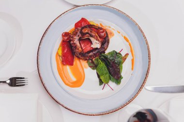 Sebze ve mürekkep balığı soslu ızgara ahtapot. Restoran, yaşam tarzı, seyahat yemekleri sebzeli ızgara ahtapot ve restoran menüsü. İtalyan taze deniz yiyeceği.