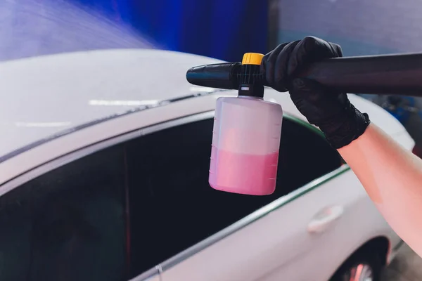 Fechar o carro de limpeza usando água de alta pressão, lavadora de jato de alta pressão em processo de lavagem de carro. espuma de cor rosa — Fotografia de Stock