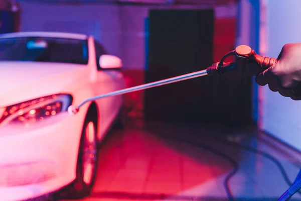 Cerrar coche de limpieza con agua de alta presión, lavadora de chorro de alta presión en proceso de lavado de coches. espuma de color rosa — Foto de Stock