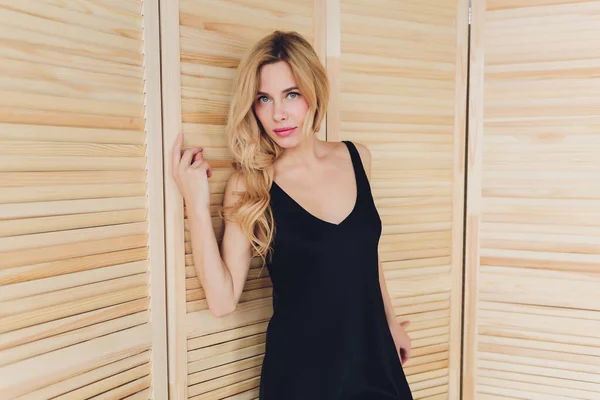 Belle jeune blonde dans une petite robe noire . — Photo