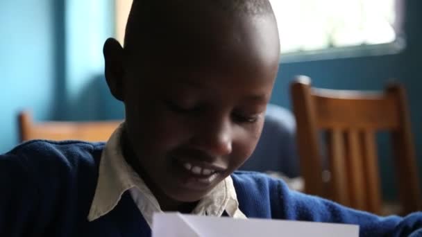 Zanzíbar, Tanzania - 15 de julio de 2019: Niño africano con la cabeza afeitada mirando hacia arriba, grandes ojos serios. en una escuela de niños — Vídeo de stock