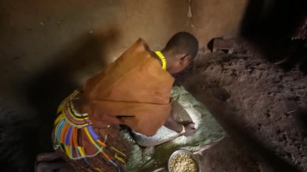 Ngorongoro, TANZÁNIA - Február 18. 2019: Afrikai nő kukoricalisztből készült közönséges ugalit készít. — Stock videók