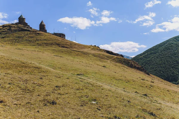 Církev Tsminda Sameba u vesnice Kazbegi Stepancminda, Gruzie, Kavkaz. — Stock fotografie