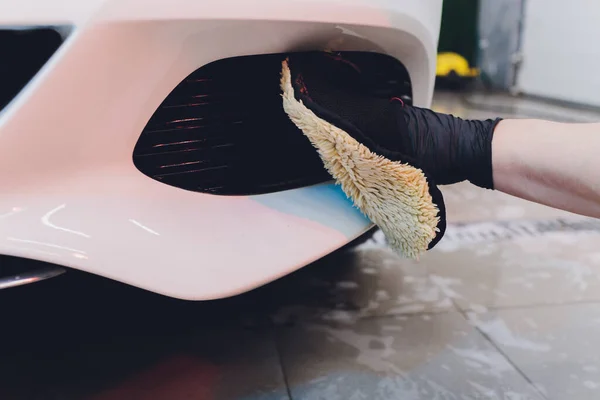 Um homem limpando carro com pano de microfibra, carro detalhando ou valeting conceito. Foco seletivo . — Fotografia de Stock