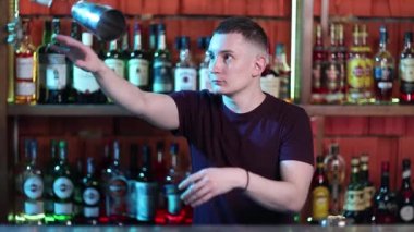 Sosyetik barda kokteyl hazırlayan yakışıklı barmen..