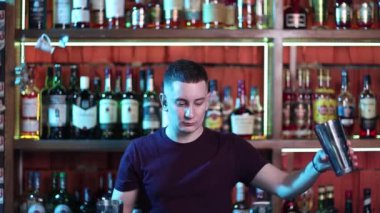 Sosyetik barda kokteyl hazırlayan yakışıklı barmen..