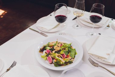 Kurutulmuş ton balığı kaplı susam tohumları ve beyaz tabakta yeşil salata..