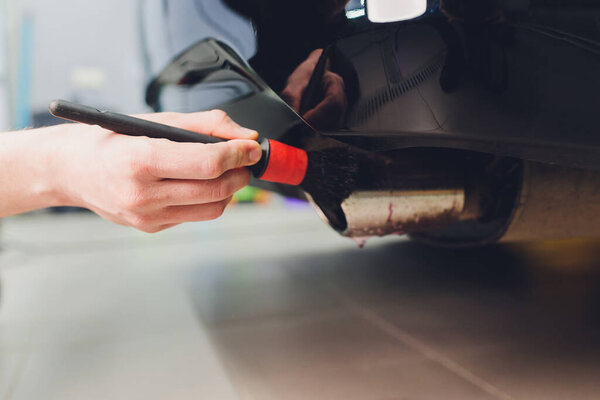 Car exhaust pipe with soap. Car wash background. brushing