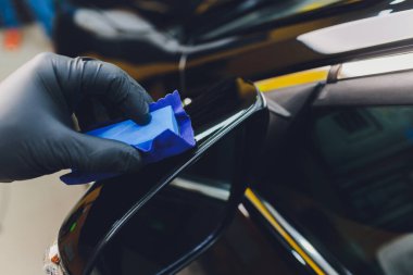 Araba temizleme - Adam arabaya nano koruyucu kaplama uyguluyor. Seçici odak.