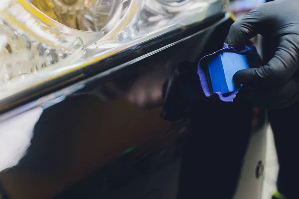 Dettagli dell'auto: l'uomo applica un rivestimento nano protettivo all'auto. Focus selettivo. — Foto Stock