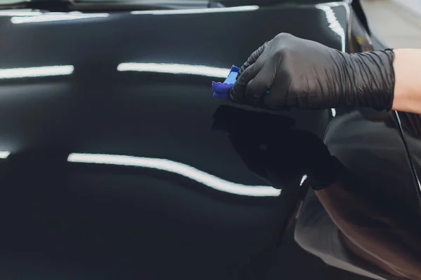 Detallado del coche - El hombre aplica una capa nano protectora al coche. Enfoque selectivo. — Foto de Stock