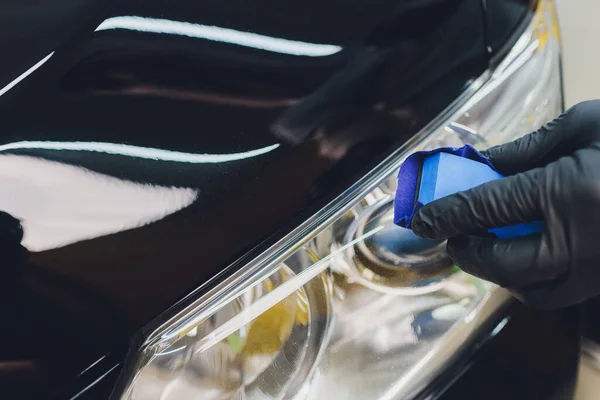Detalhes do carro - Homem aplica revestimento nano protetor para o carro. Foco seletivo. — Fotografia de Stock