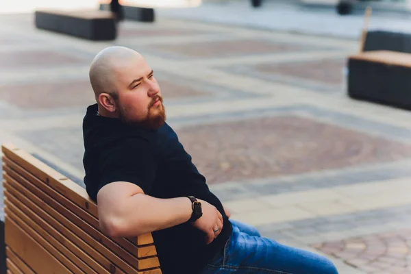 Portrait of a bald handsome bearded man in a black t-shirt on the street, who looks away. — Stock Photo, Image