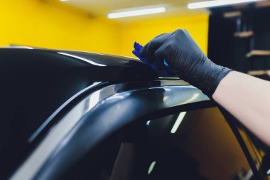 Araba temizleme - Adam arabaya nano koruyucu kaplama uyguluyor. Seçici odak.