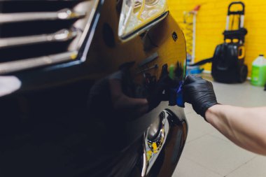 Araba temizleme - Adam arabaya nano koruyucu kaplama uyguluyor. Seçici odak.