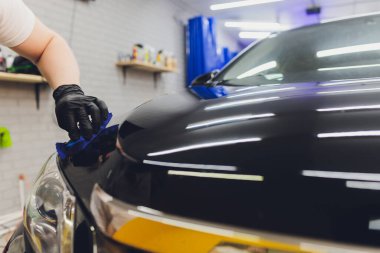 Araba temizleme - Adam arabaya nano koruyucu kaplama uyguluyor. Seçici odak.