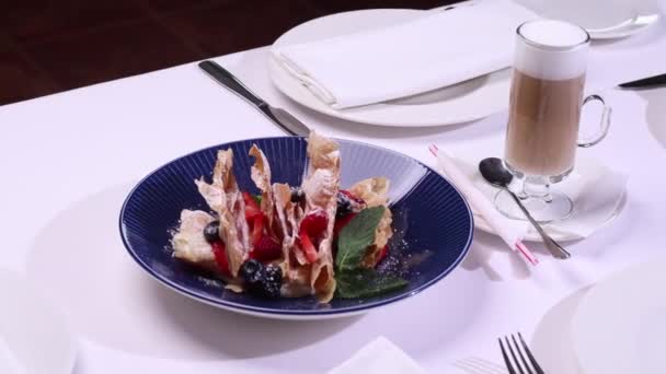 Французский десерт Millefeuille слоистого теста с кремом, малиной, черникой на тарелке на бетонном столе, вид сверху, крупным планом, макро . — стоковое видео