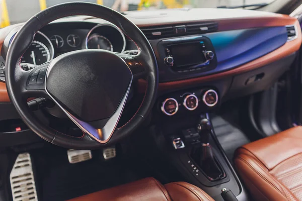 Interior oscuro coche de lujo - volante, palanca de cambios y tablero de instrumentos. Lujo interior del coche. Asientos cómodos beige, volante, salpicadero, climatización, velocímetro, pantalla . — Foto de Stock