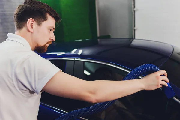 Knappe man schoonmaken van auto met hete stoom. — Stockfoto