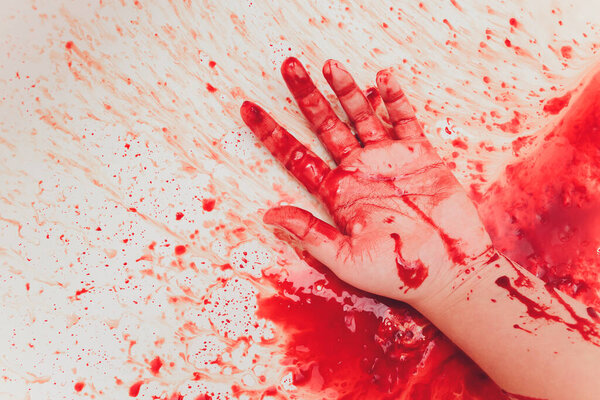 Bloody hand of depressed woman in shower.