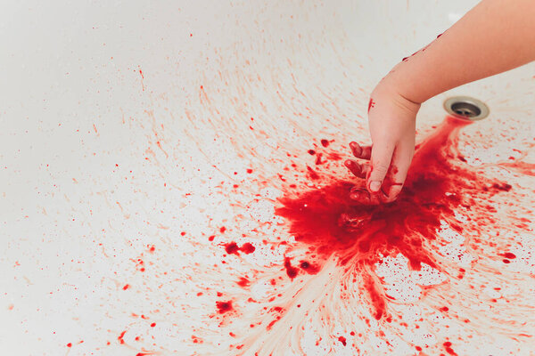 Bloody hand of depressed woman in shower.