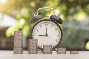 madeni para ile saat yeşil bokeh ışık arka plan üzerinde kazık. 