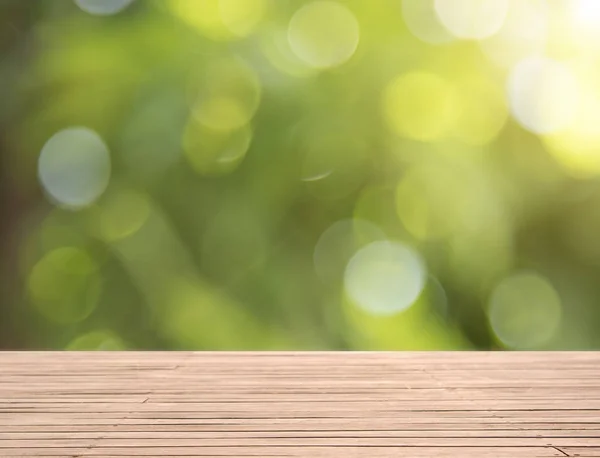 Tablero de madera sobre fondo bokeh verde para la visualización del producto — Foto de Stock